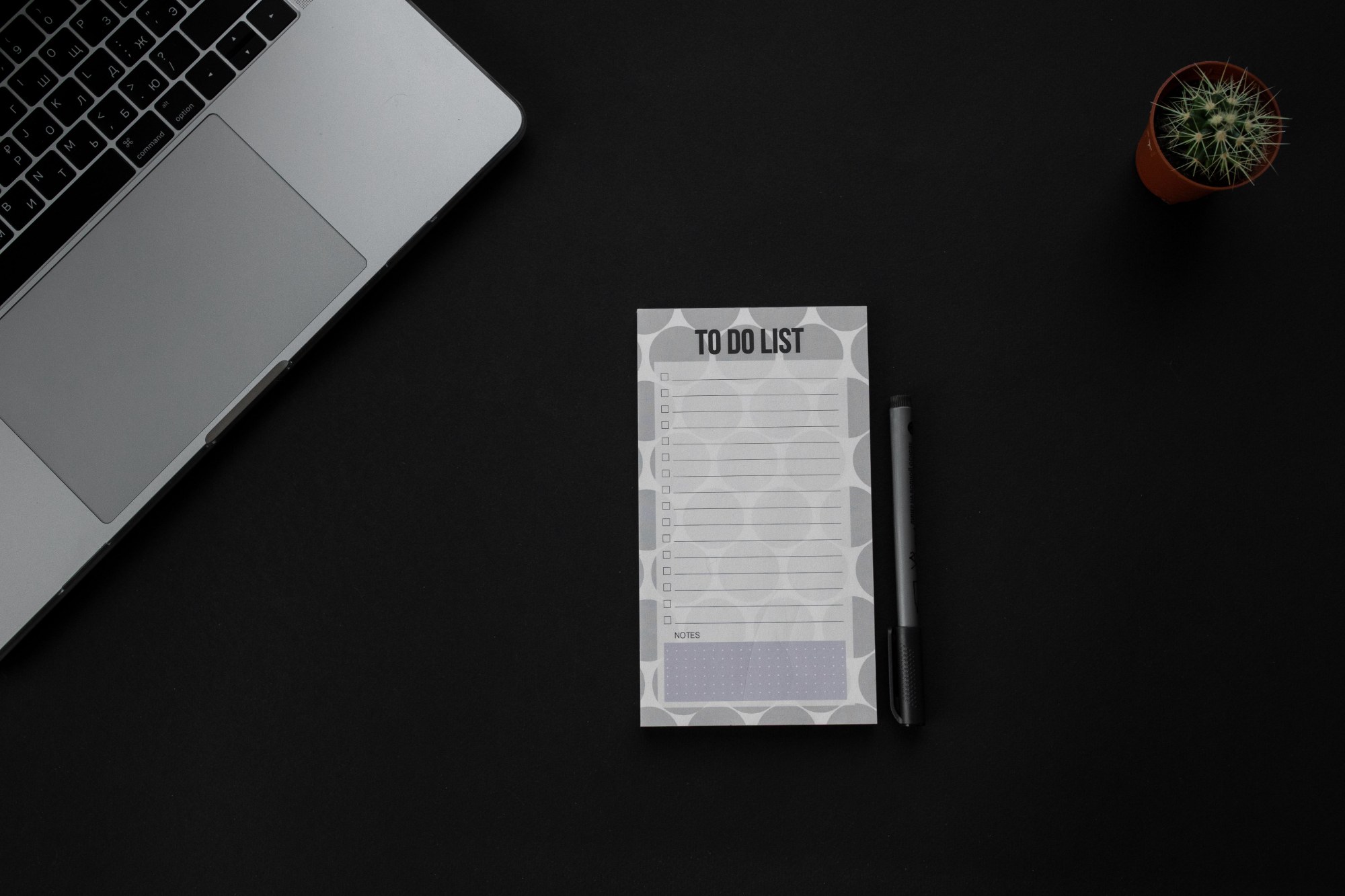 Concept visual: a checklist beside a laptop on a dark desk
